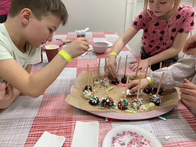 Дети создают торты на палочке на мастер-классе